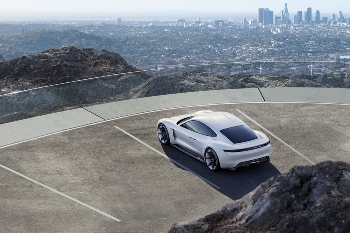 White Porsche Taycan electric supercar parked overlooking city