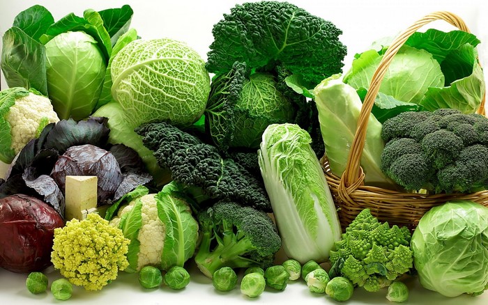 Assortment of fresh cruciferous vegetables including cabbage, broccoli, and cauliflower