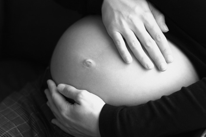 Pregnant woman holding her belly