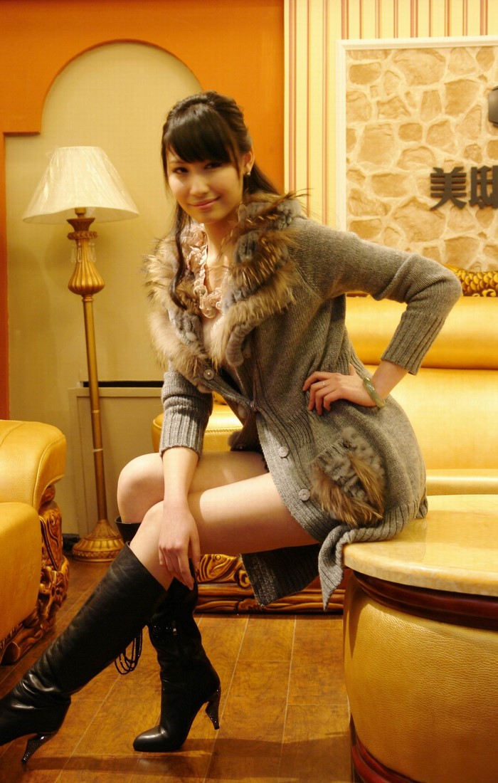 Diana Xu sitting in a fur-trimmed cardigan