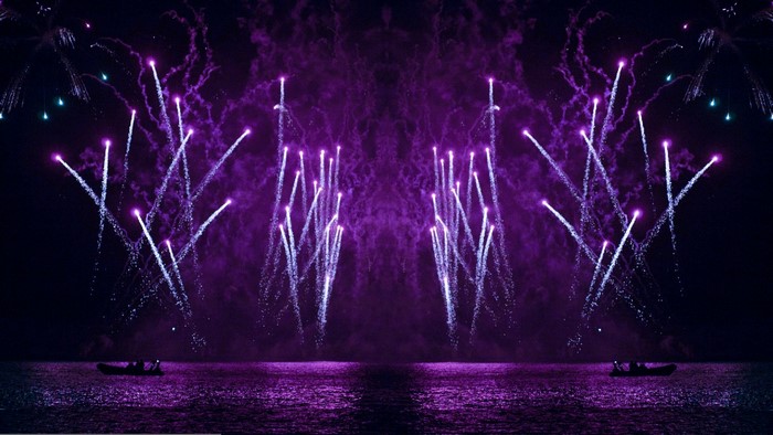 Purple fireworks over the water with boats