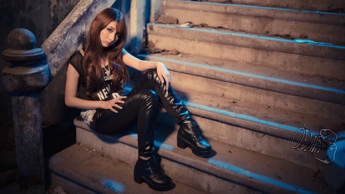 Asian woman in black outfit sitting on stairs