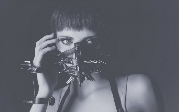 Woman wearing a spiked mask and wrist cuffs