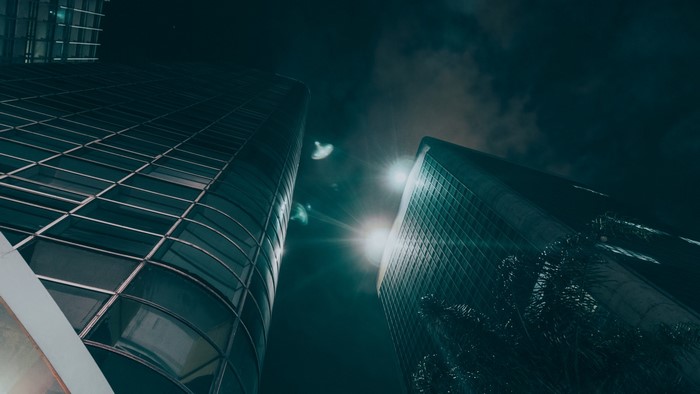 Two skyscrapers at night with bright lights