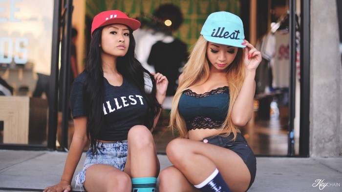 Two Asian women wearing illest t-shirts and baseball caps