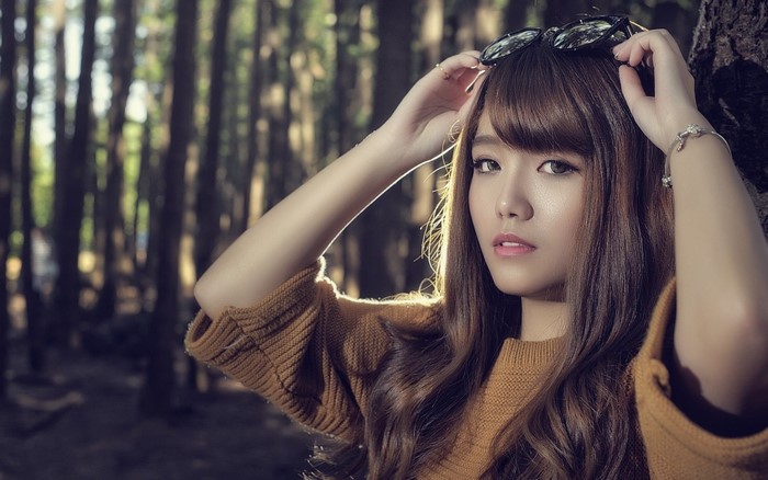 Woman with sunglasses on head in forest