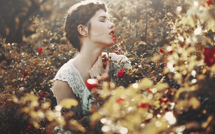 Woman smelling roses in a garden