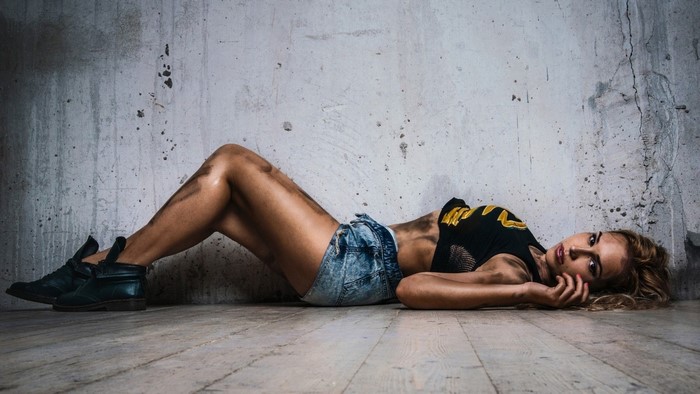 Woman in jean shorts lying on floor