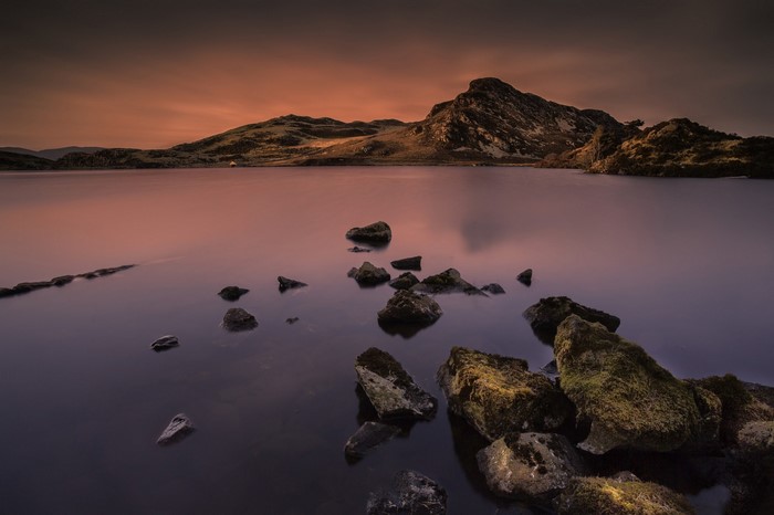 Rocky lake at sunset with mountain landscape