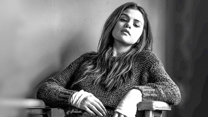 Selena Gomez sitting in a sweater