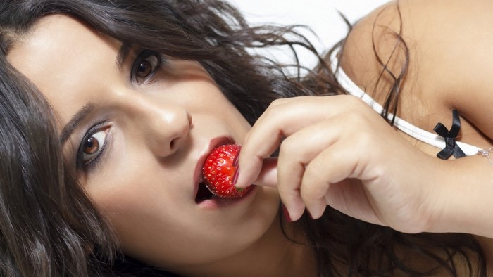 Woman eating a strawberry