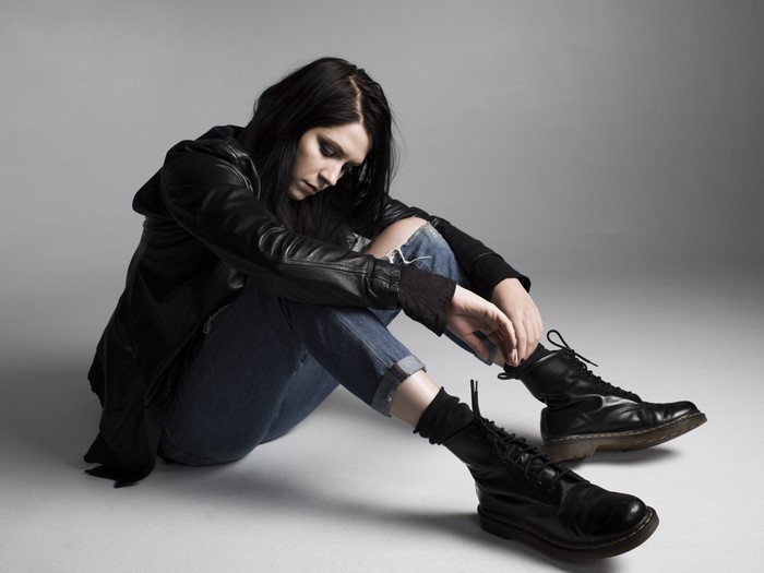 K. Flay sitting on the floor in a studio