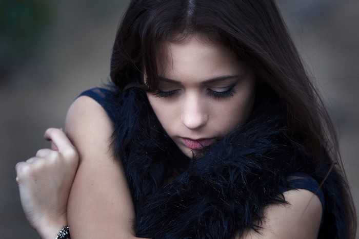 Woman with long dark hair and fur collar