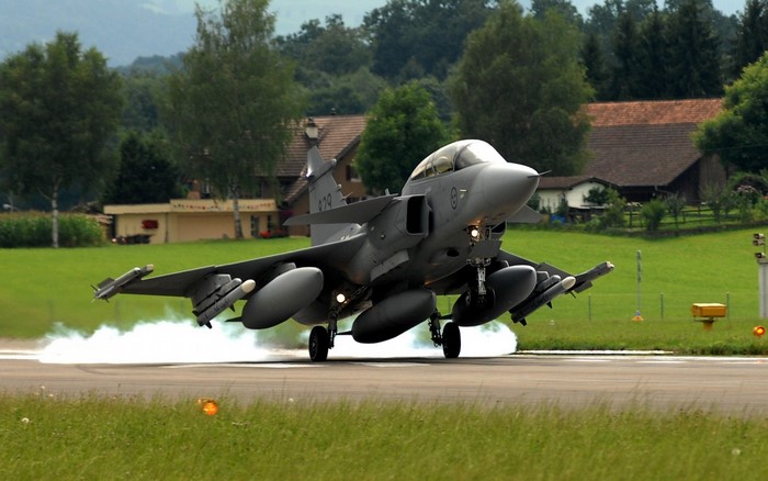 Saab JAS 39 Gripen fighter jet landing on runway