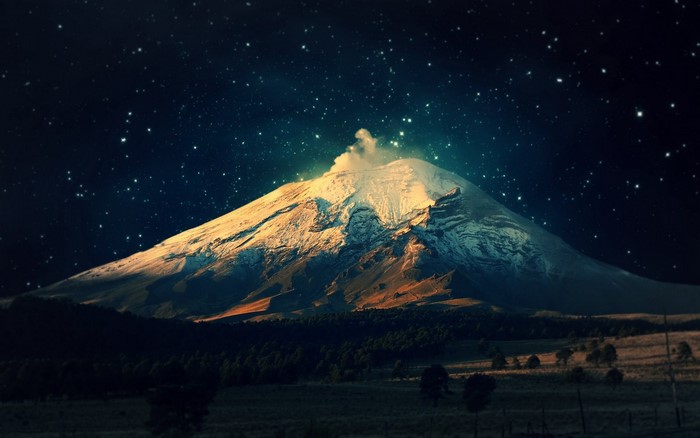 Snow-capped volcano under a starry night sky