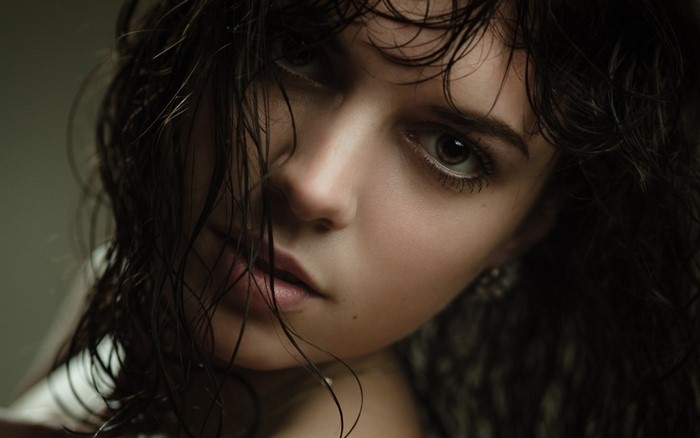 Close-up portrait of a young woman with wet dark hair