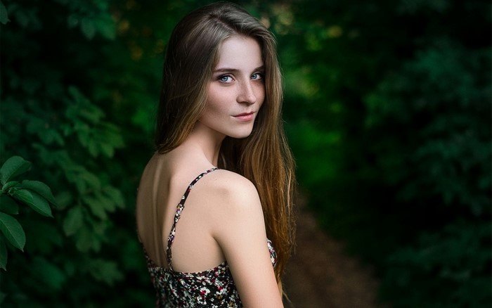 Woman with long brown hair in a floral dress