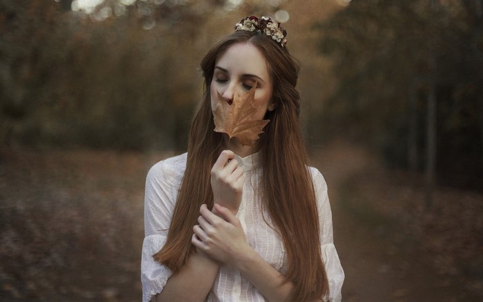 Woman with flower crown holding a leaf