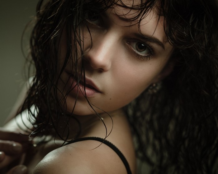 Close-up portrait of a young woman with wet hair