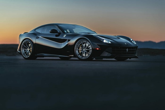 Black Ferrari F12berlinetta parked at sunset