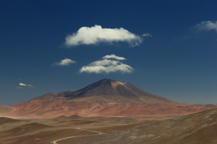 Volcano and clouds over a desert landscape
