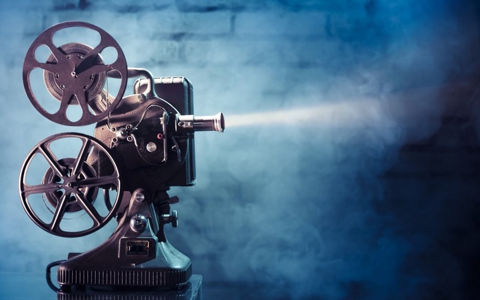 Vintage 8mm film projector emitting light beam