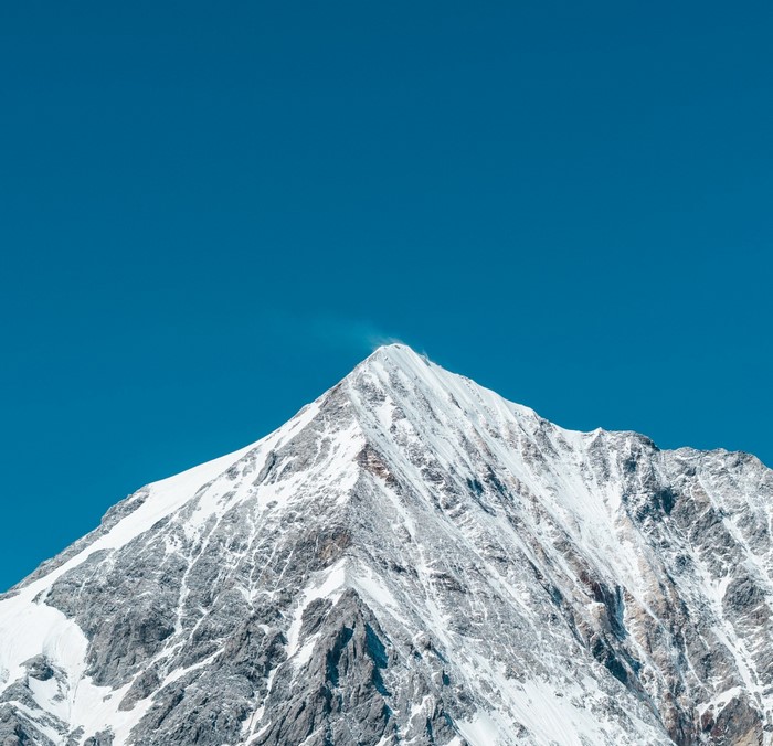 Snow-covered mountain peak against a clear blue sky