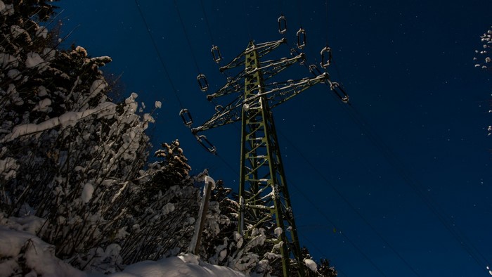 Power tower in a snowy landscape at night