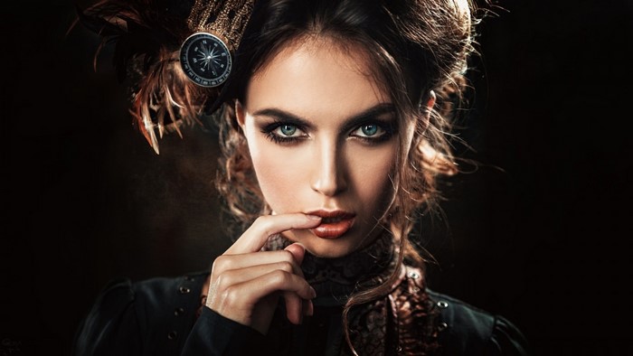 Woman with compass in hair, dark background