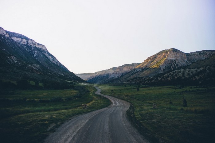 Winding road through a mountain valley at sunrise