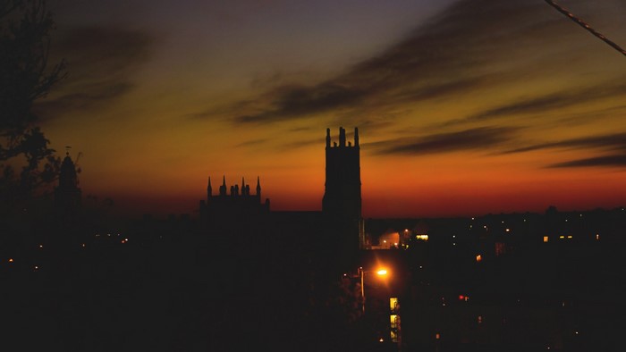 Silhouette of a church tower against a sunset sky