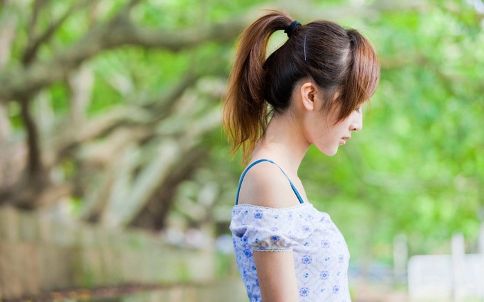 Young Woman in White Floral Dress with Ponytail