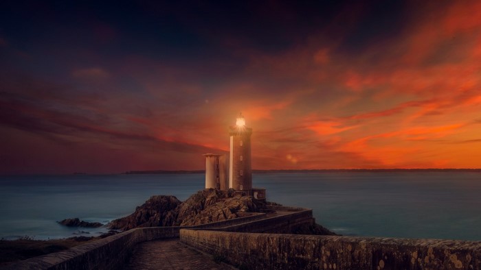 Lighthouse at Sunset Over Calm Sea