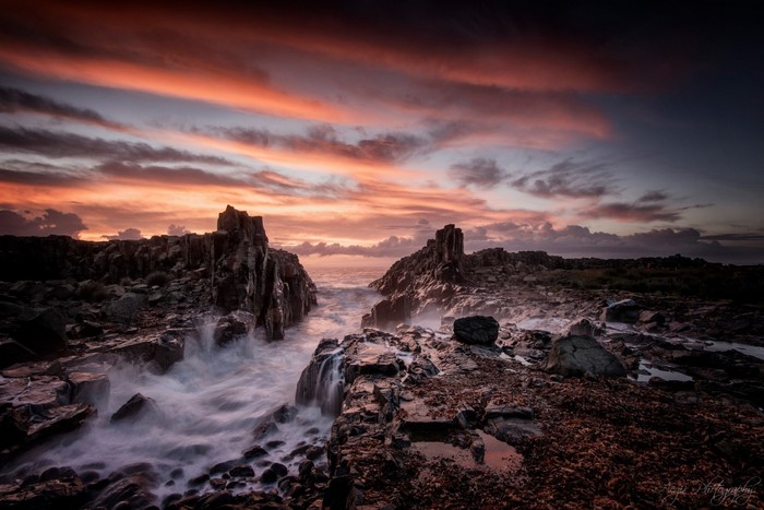 Rocky coast with crashing waves at sunset