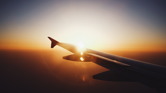 Airplane wing at sunset with lens flare