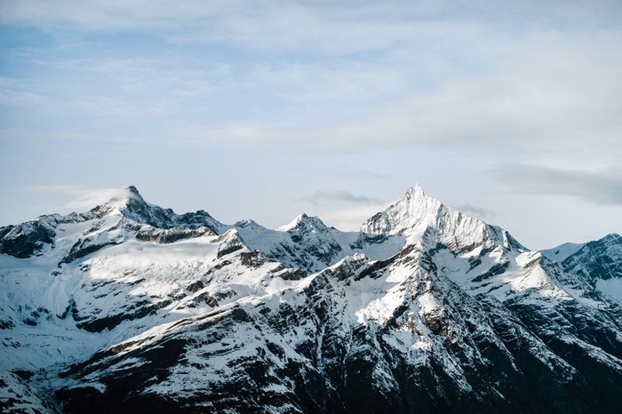 Snow-covered mountains under a cloudy sky