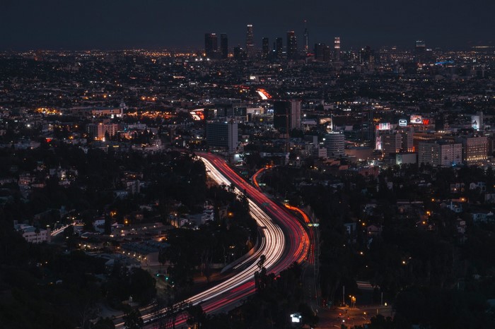 Nighttime Los Angeles cityscape with light trails on highway