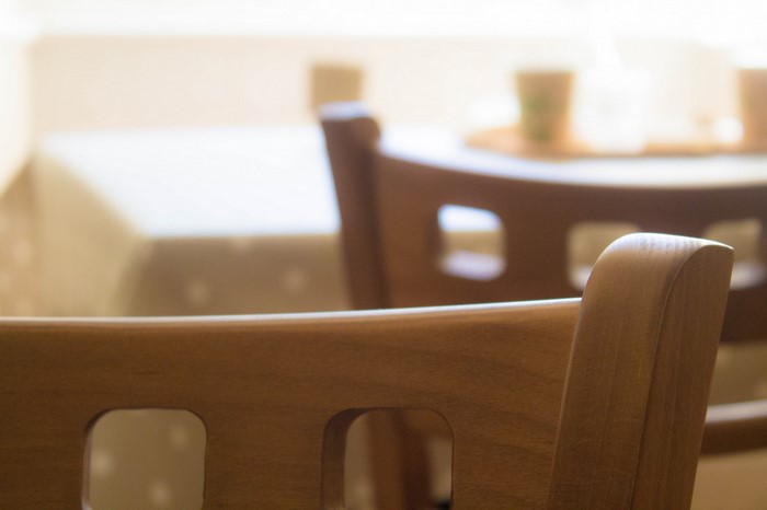 Wooden chairs at a table with a tablecloth