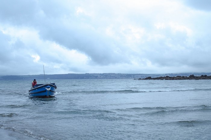 Blue boat with person in the sea near St Michael's Mount