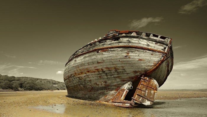 Wrecked wooden boat on a sandy shore