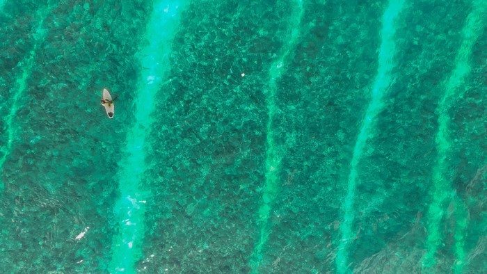 Person on a surfboard in clear green water