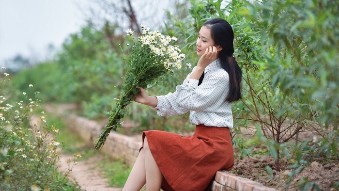 Woman holding a bouquet of white flowers outdoors