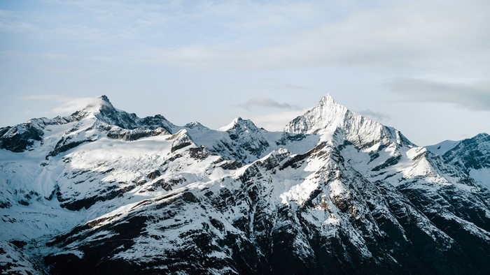 Snow-covered mountain range under a cloudy sky