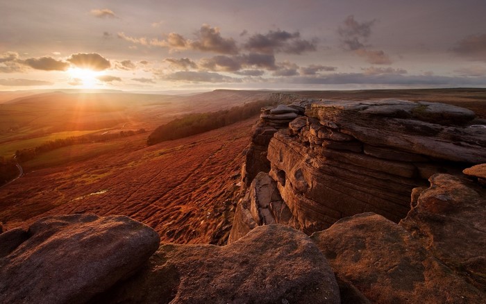 Sunset over rocky cliffs and heather moorland