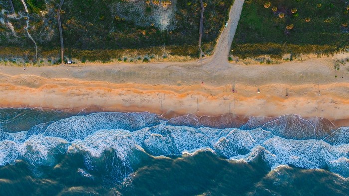 Aerial view of a sandy beach with ocean waves