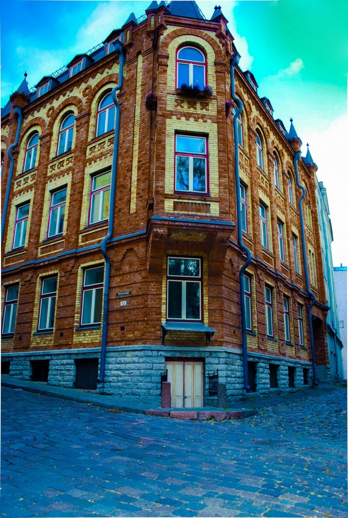 Brick building with arched windows on a cobblestone street