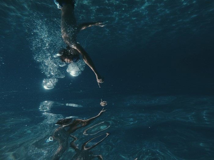 Underwater view of a person diving with bubbles
