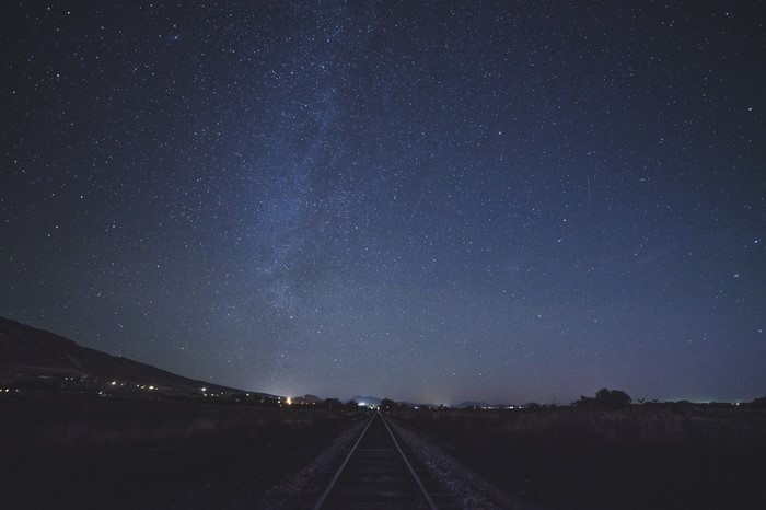 Train tracks under the Milky Way at night