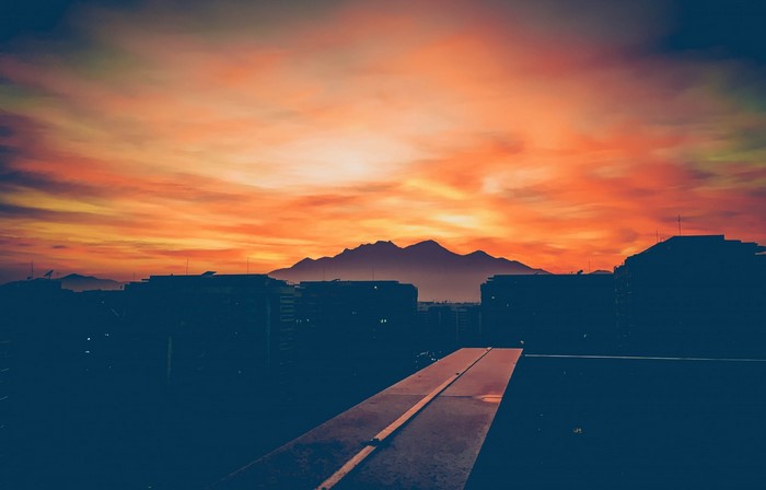 Silhouette of mountains and buildings at sunset