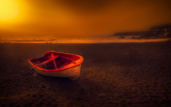 Boat on a beach at sunset